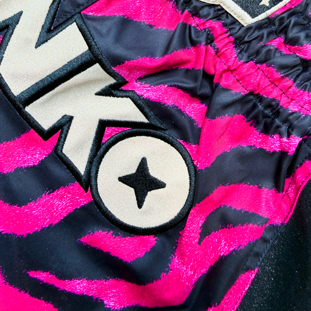 Black and Pink Tiger Strip Print, Black Glittery Sides, Golden Glittery Front Logo.
Muay Thai shorts designed for unrestricted movement and reliable performance.

From the Midnight Hunt Collection

KEY FEATURES:
Quick-dry and lightweight
Flexible fabric
Side slits for freedom of movement
Adjustable waistband
Unique sublimation print
Embroidered logo