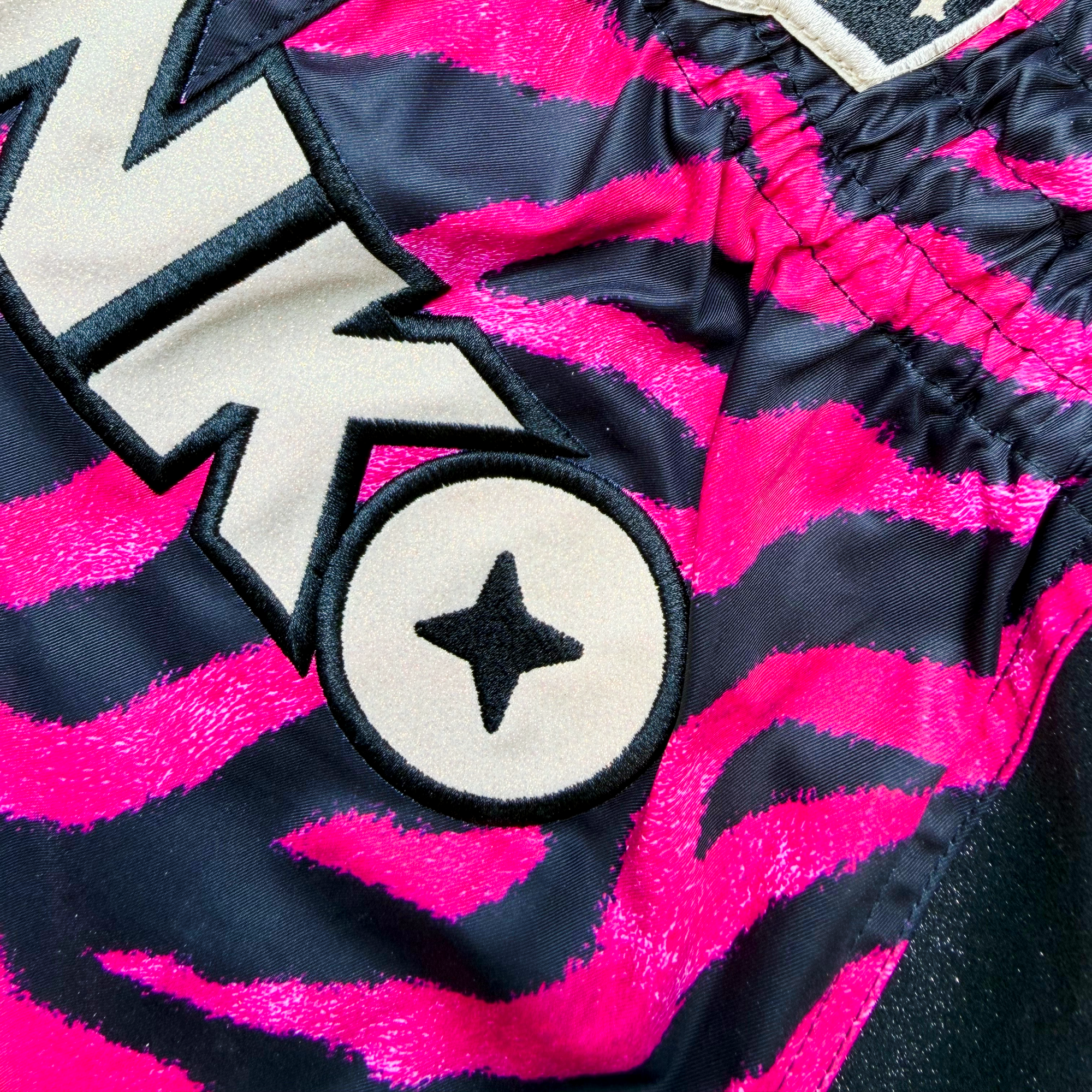 Black and Pink Tiger Strip Print, Black Glittery Sides, Golden Glittery Front Logo.
Muay Thai shorts designed for unrestricted movement and reliable performance.

From the Midnight Hunt Collection

KEY FEATURES:
Quick-dry and lightweight
Flexible fabric
Side slits for freedom of movement
Adjustable waistband
Unique sublimation print
Embroidered logo